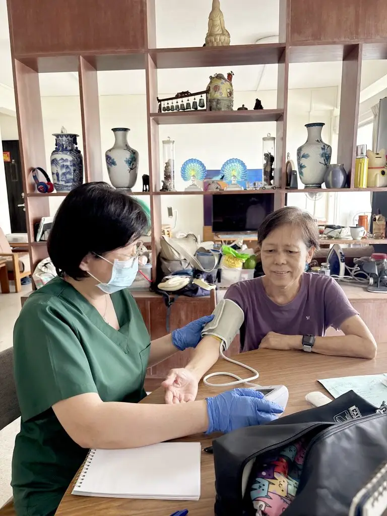 Metta HomeCare nurse checking an elderly woman’s blood pressure at home