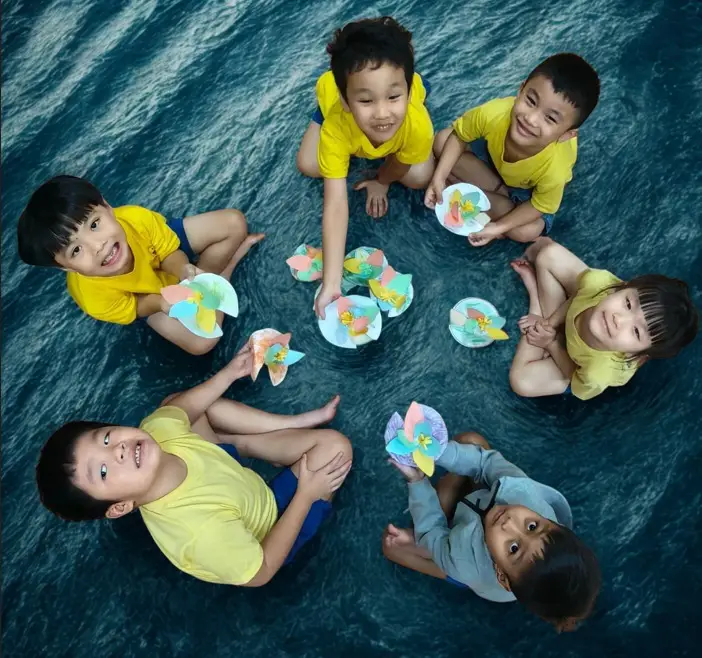 Children from Metta Preschool @ Punggol seated in a circle with their craft work